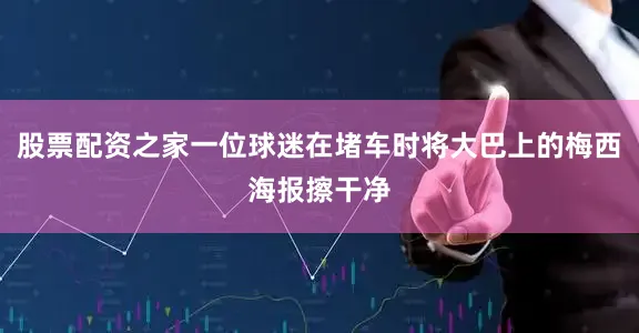 股票配资之家一位球迷在堵车时将大巴上的梅西海报擦干净